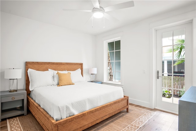 bedroom featuring access to exterior, light wood-type flooring, multiple windows, and ceiling fan