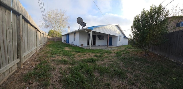 back of house featuring a patio area and a lawn