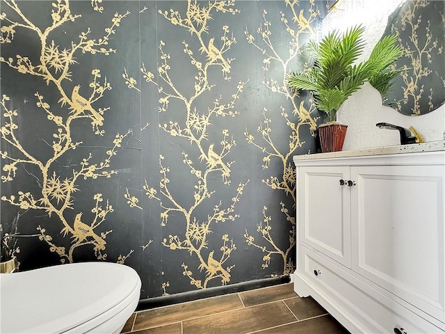 2902 Saint Joseph St Unit F, Corpus Christi, TX 78418 - bathroom with wood tiled floors, baseboards, toilet, and wallpapered walls