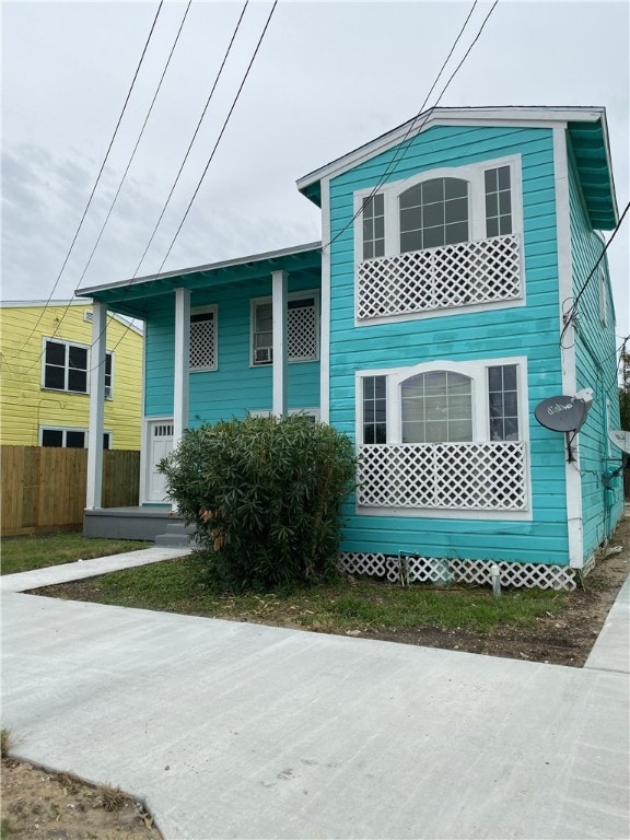 view of front of home featuring a porch and fence