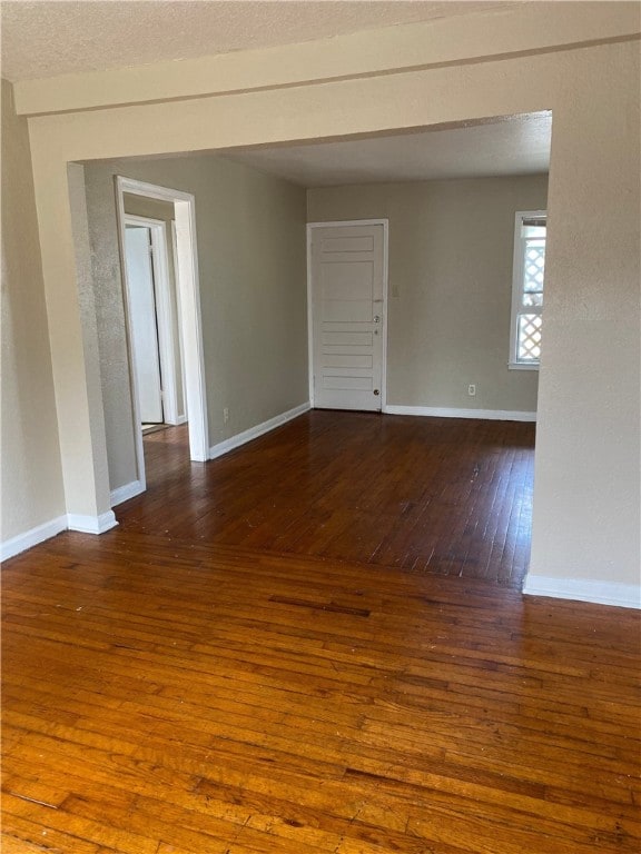 spare room with wood-type flooring, baseboards, and a textured ceiling