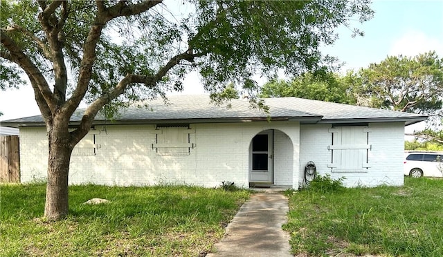 3173 Baybrook Dr, Corpus Christi, TX 78418 - ranch-style house with brick siding, roof with shingles, and a front yard