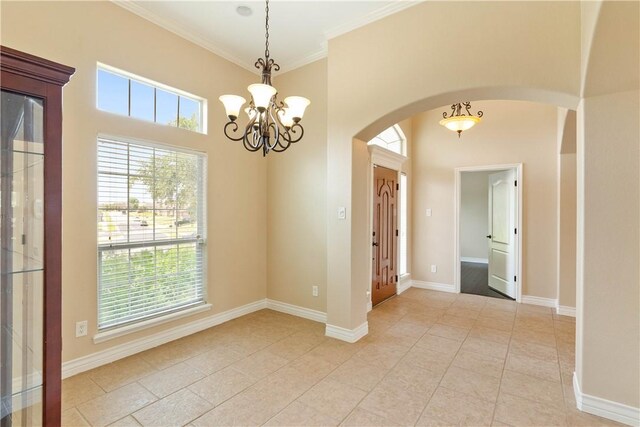 4529 Ballad Tree Dr, Corpus Christi, TX 78410 - unfurnished room featuring a chandelier, arched walkways, plenty of natural light, light tile patterned floors, and crown molding