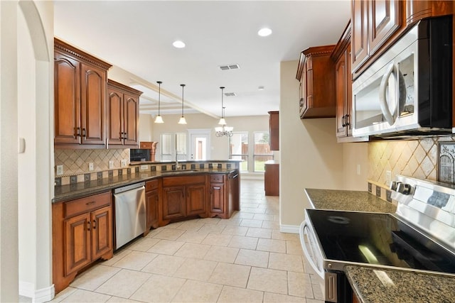 4529 Ballad Tree Dr, Corpus Christi, TX 78410 - kitchen with stainless steel appliances, a peninsula, decorative backsplash, light tile patterned floors, and recessed lighting
