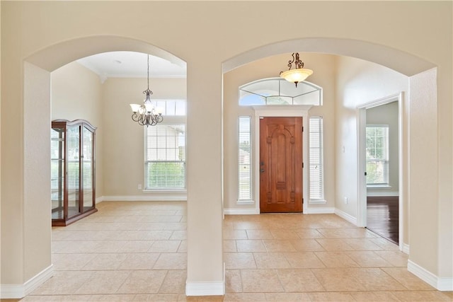 4529 Ballad Tree Dr, Corpus Christi, TX 78410 - entryway with light tile patterned flooring, plenty of natural light, ornamental molding, a chandelier, and arched walkways