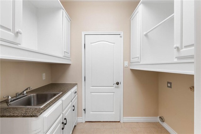 4529 Ballad Tree Dr, Corpus Christi, TX 78410 - laundry room with light tile patterned floors, cabinet space, and hookup for an electric dryer