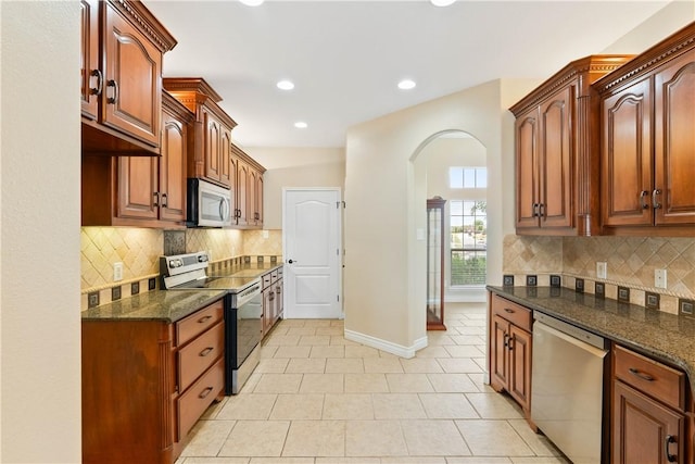 4529 Ballad Tree Dr, Corpus Christi, TX 78410 - kitchen with stainless steel appliances, arched walkways, light tile patterned floors, tasteful backsplash, and recessed lighting