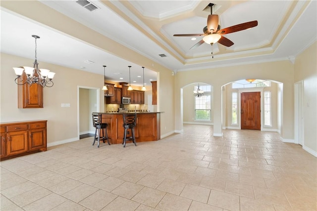 4529 Ballad Tree Dr, Corpus Christi, TX 78410 - kitchen with arched walkways, a chandelier, open floor plan, brown cabinetry, and crown molding