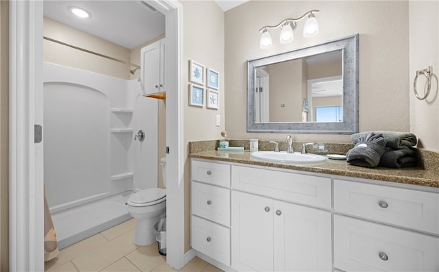 bathroom with a shower, toilet, vanity, and tile patterned flooring