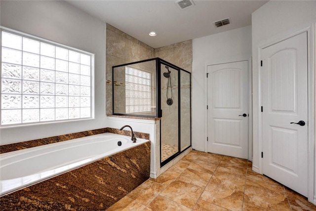 bathroom featuring shower with separate bathtub