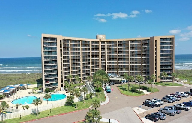 view of building exterior featuring a water view and a community pool