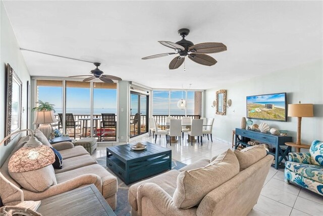 tiled living room with expansive windows and ceiling fan