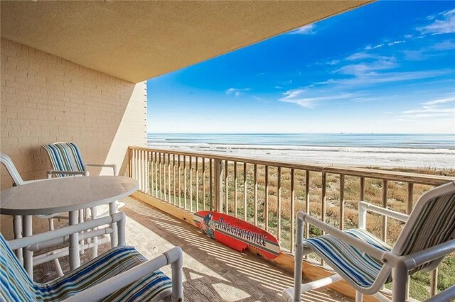 balcony featuring a water view and a beach view