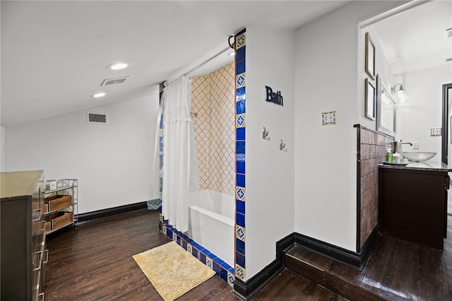 interior space with vanity, wood-type flooring, and shower / tub combo with curtain