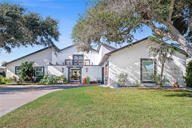 view of front of home featuring a balcony and a front lawn