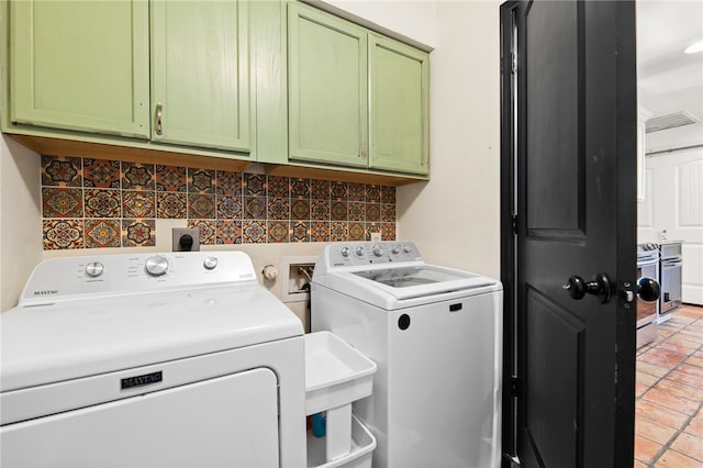 washroom with cabinets and washing machine and dryer