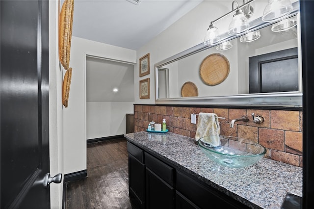 bathroom with hardwood / wood-style floors, vanity, and tasteful backsplash