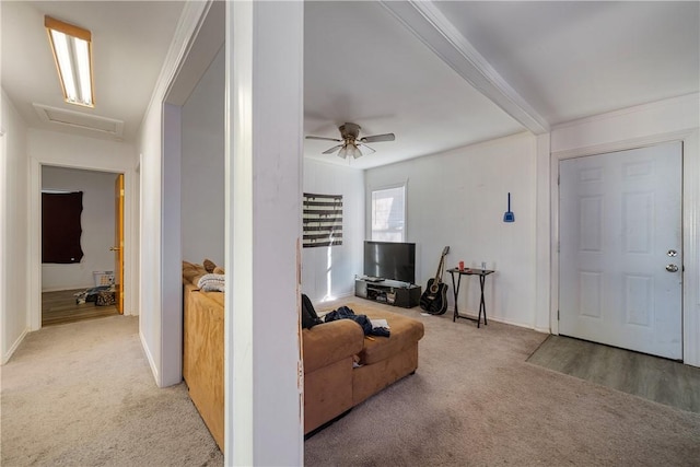 living room featuring ceiling fan, beam ceiling, and light carpet