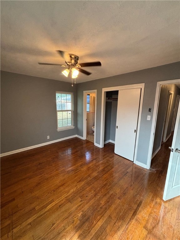 unfurnished bedroom with ceiling fan, hardwood / wood-style floors, ensuite bathroom, and a textured ceiling