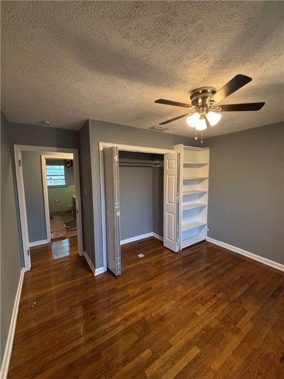 unfurnished bedroom featuring ceiling fan, dark hardwood / wood-style flooring, and a textured ceiling