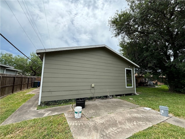 view of side of home featuring a patio area and a yard