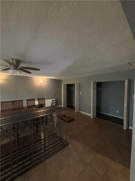 tiled dining room with a textured ceiling and ceiling fan