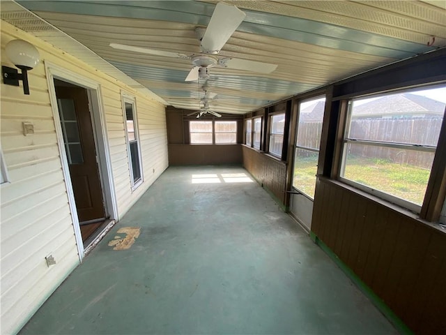 unfurnished sunroom with ceiling fan