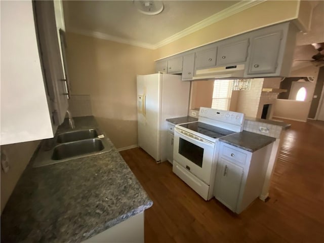 kitchen with white appliances, kitchen peninsula, dark hardwood / wood-style floors, white cabinetry, and sink