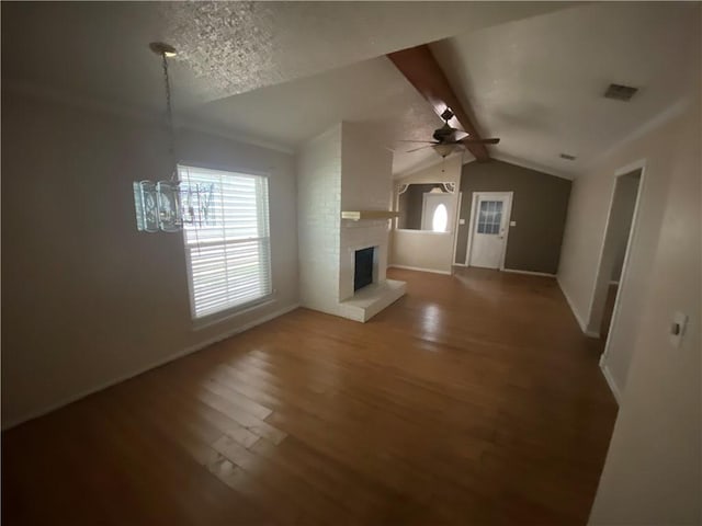 unfurnished living room with hardwood / wood-style flooring, a textured ceiling, a brick fireplace, ceiling fan, and vaulted ceiling with beams