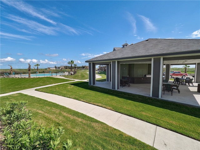 view of yard featuring a water view, a patio area, and a pool