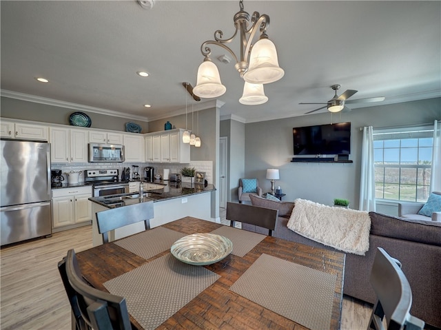 dining space with ceiling fan, light hardwood / wood-style flooring, and crown molding