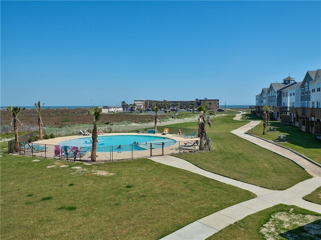 view of swimming pool with a lawn