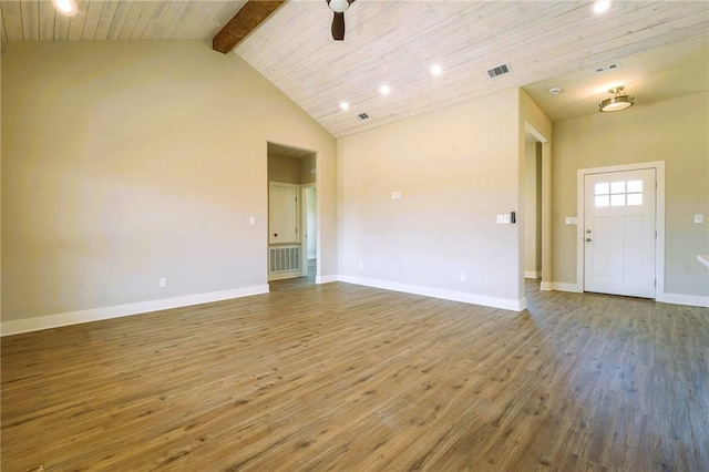 spare room featuring visible vents, beam ceiling, baseboards, and wood finished floors