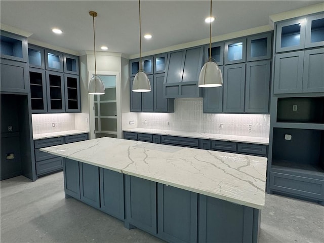 2425 Manuel, Corpus Christi, TX 78414 - kitchen featuring backsplash, a kitchen island, concrete floors, light stone countertops, and decorative light fixtures