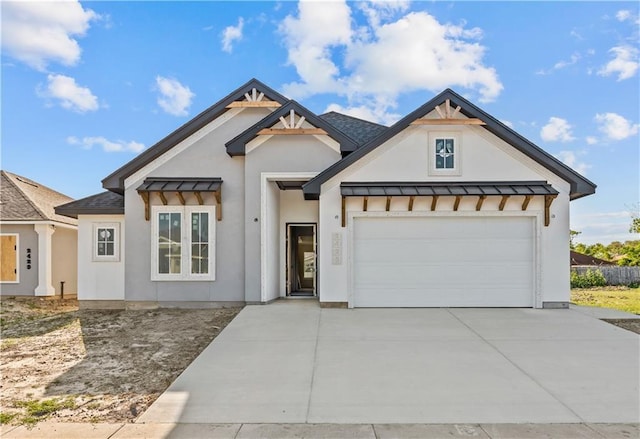 2425 Manuel, Corpus Christi, TX 78414 - view of front facade with a standing seam roof, concrete driveway, an attached garage, stucco siding, and metal roof