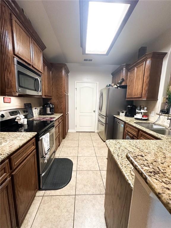 4734 Fox Trot Dr, Corpus Christi, TX 78413 - kitchen with visible vents, light tile patterned floors, light stone countertops, and stainless steel appliances
