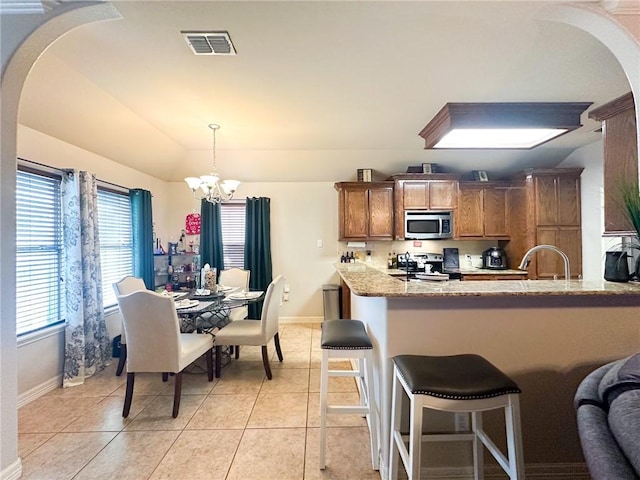 4734 Fox Trot Dr, Corpus Christi, TX 78413 - kitchen with an inviting chandelier, arched walkways, brown cabinetry, stainless steel appliances, and visible vents