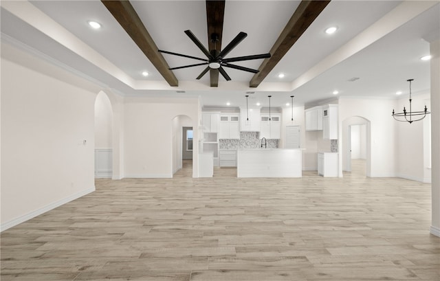 4133 Azali Dr, Corpus Christi, TX 78414 - unfurnished living room with arched walkways, a ceiling fan, light wood-style floors, baseboards, and beamed ceiling