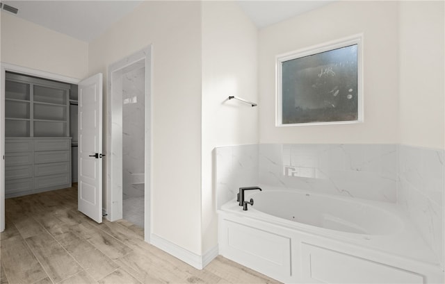 bathroom featuring a washtub and wood-type flooring