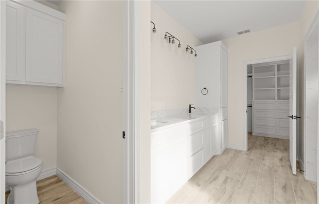 bathroom with hardwood / wood-style floors, vanity, and toilet