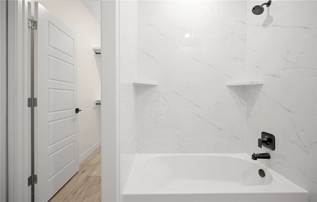 bathroom with tiled shower / bath combo and hardwood / wood-style flooring