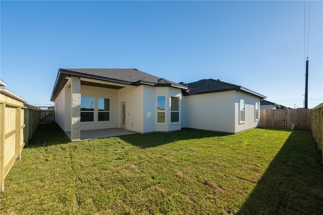 rear view of property featuring a yard and a patio