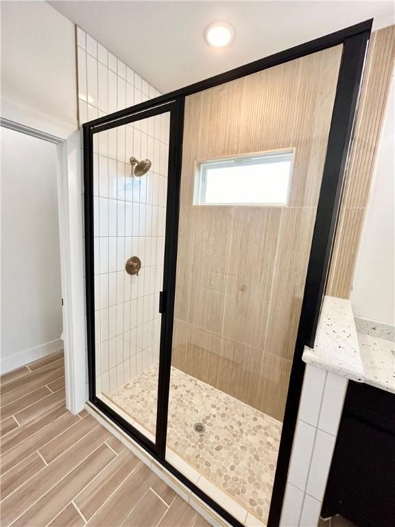 bathroom featuring a stall shower and wood finish floors