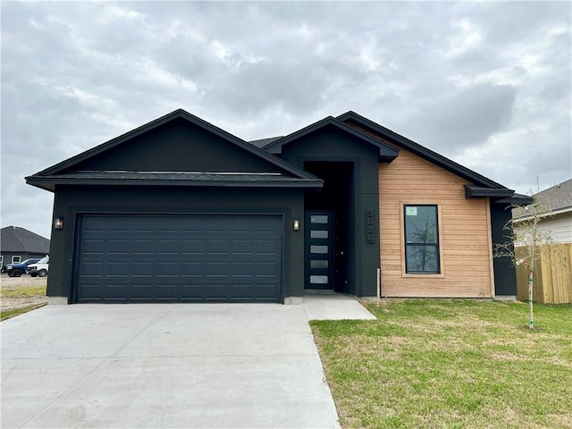 view of front of house with a garage, driveway, a front lawn, and fence