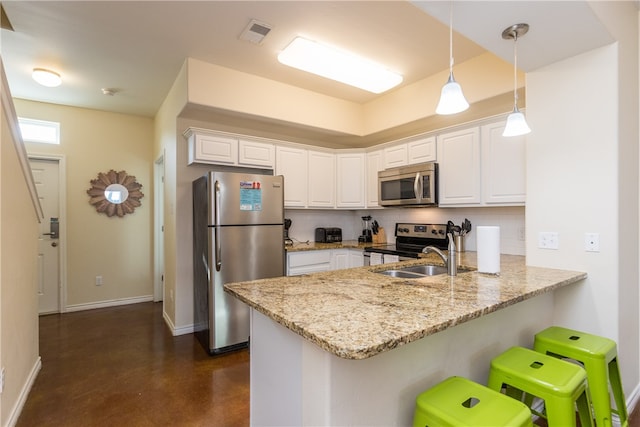 kitchen with kitchen peninsula, white cabinetry, stainless steel appliances, and decorative light fixtures