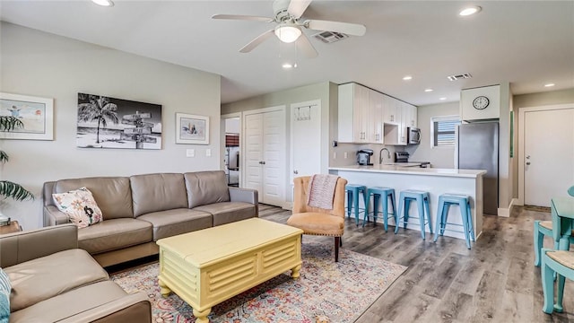 living area with a ceiling fan, recessed lighting, visible vents, and light wood-style flooring