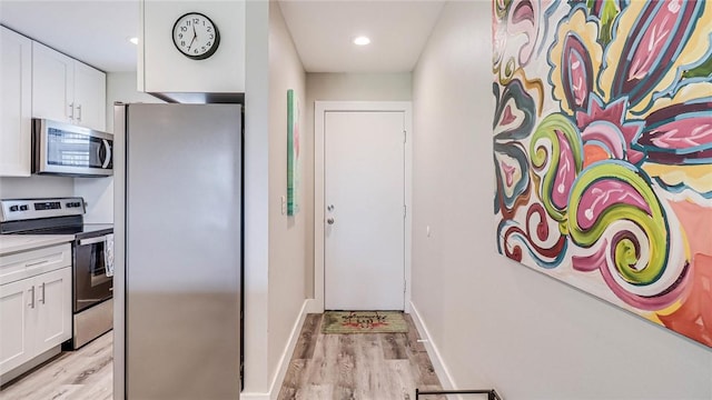 interior space with recessed lighting, light wood-style flooring, and baseboards