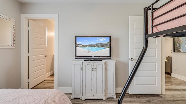 bedroom with baseboards and wood finished floors