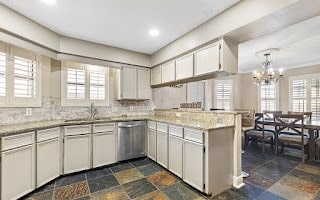 kitchen with a wealth of natural light, sink, dishwasher, and tasteful backsplash