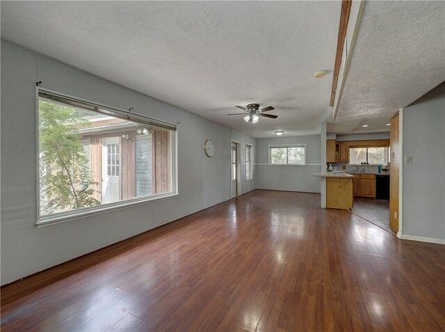 unfurnished living room featuring dark hardwood / wood-style flooring, a textured ceiling, and ceiling fan